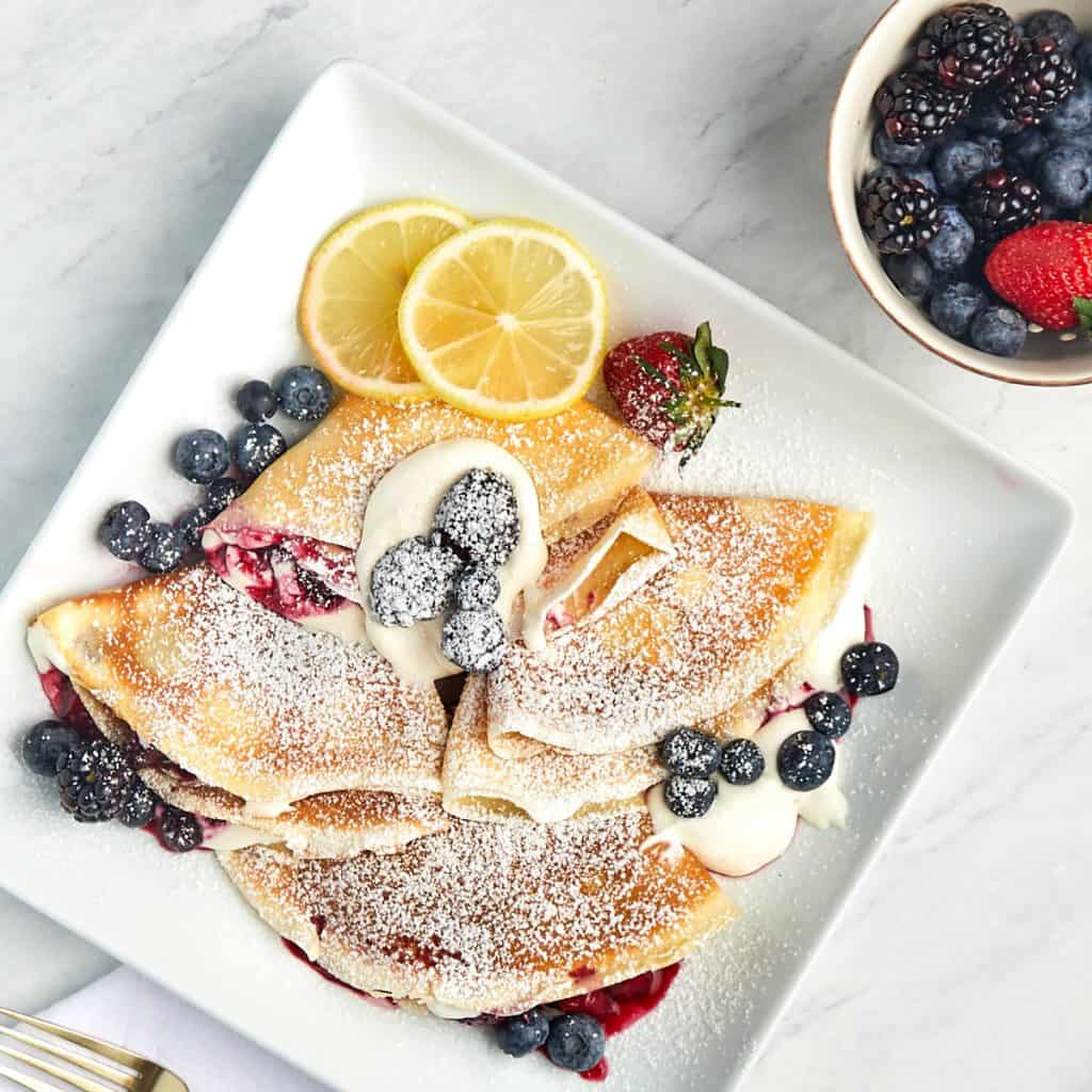 image of crepes with whipped cream and mixed berries