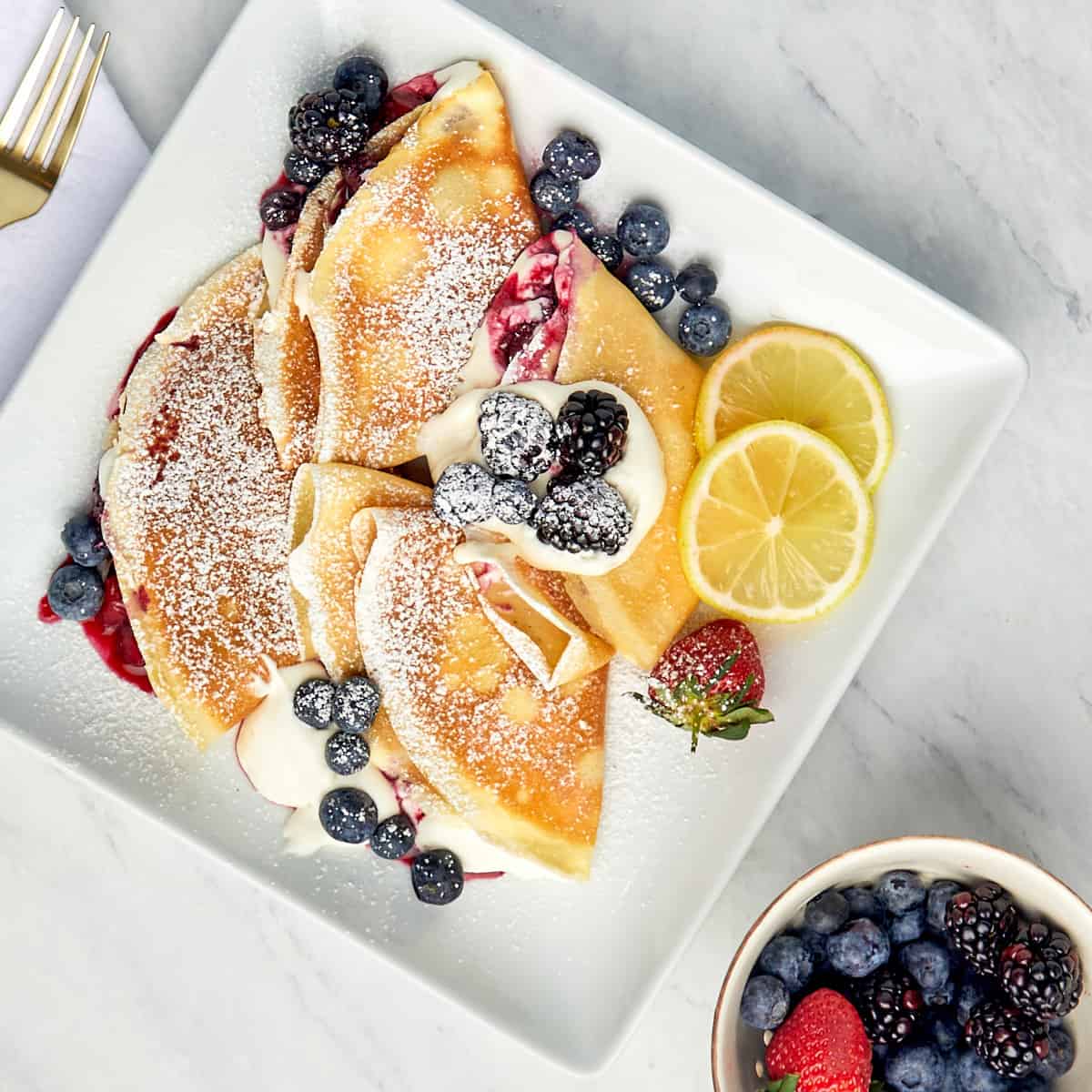 image of crepes with whipped cream and mixed berries