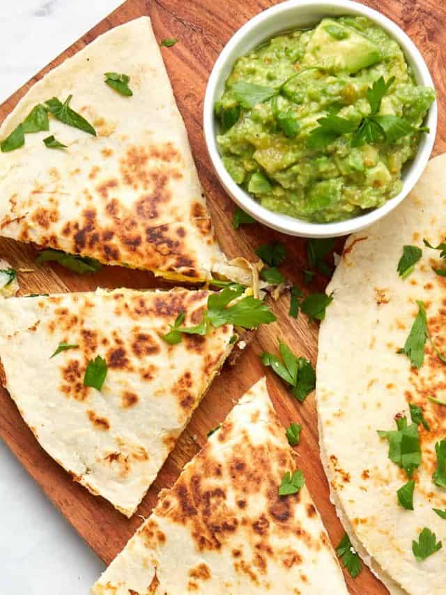 cooked breakfast quesadillas with bacon and spinach served with avocado