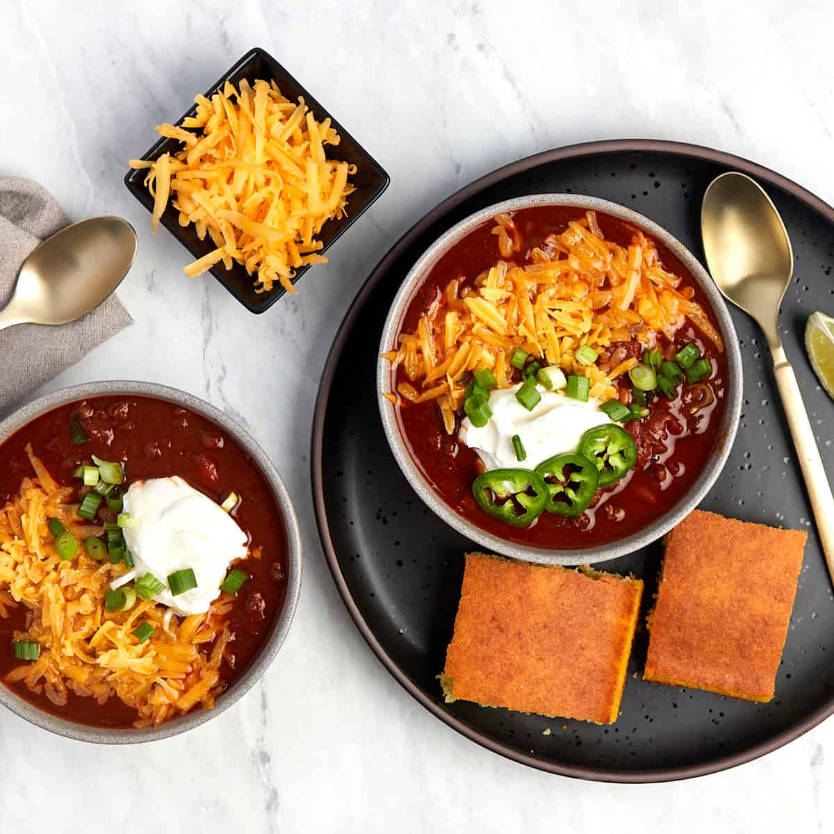 gameday chili topped with cheese, sour cream, jalapenos with a side of corn bread