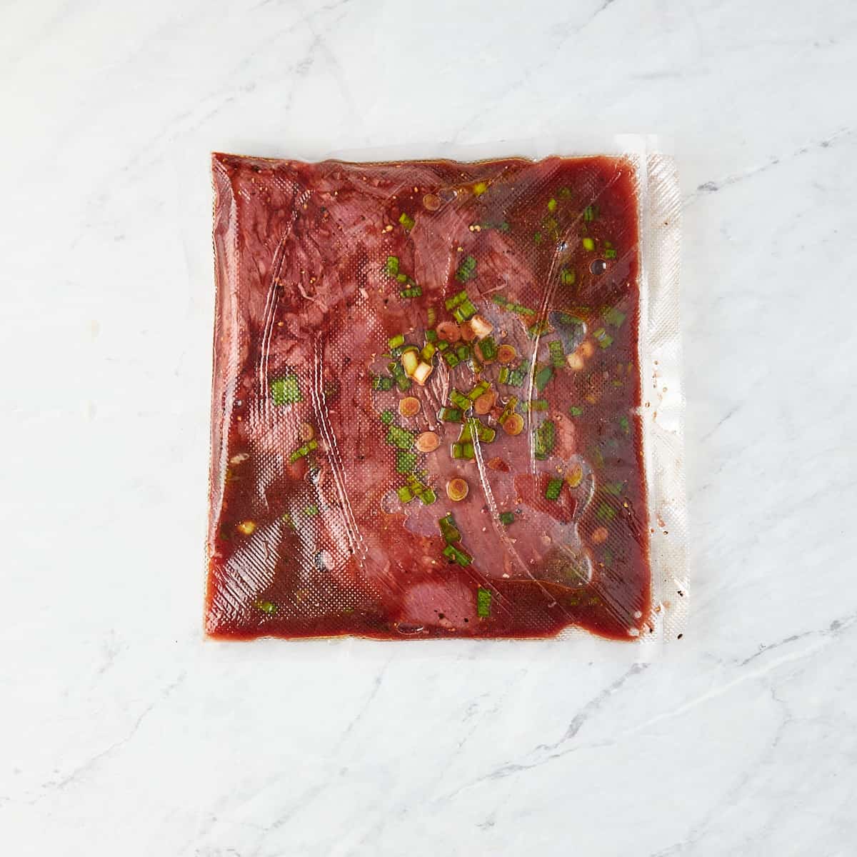 flank steak in ziplock bag with marinade