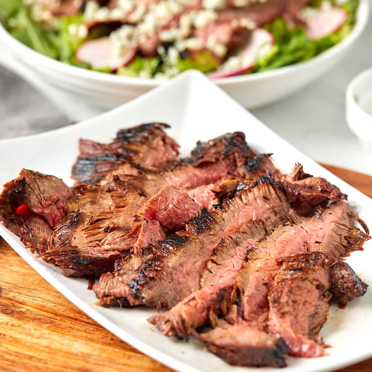 sliced grilled flank steak on a white plate