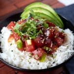 ahi tuna on top of rice with slices of avocado