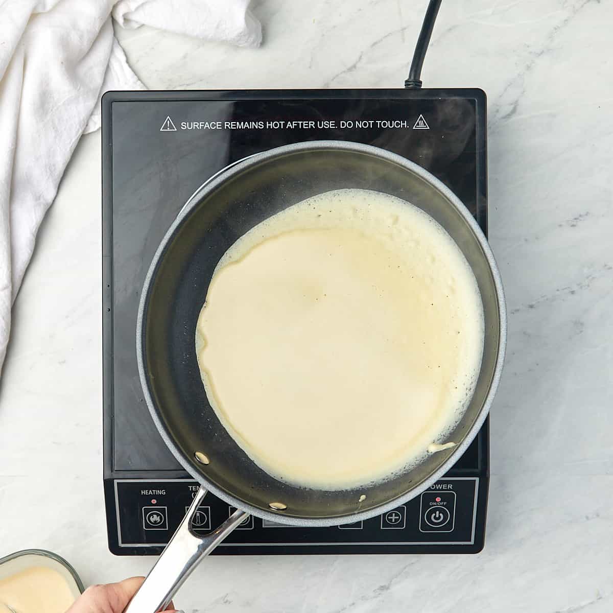 crepe batter in a pan being swirled