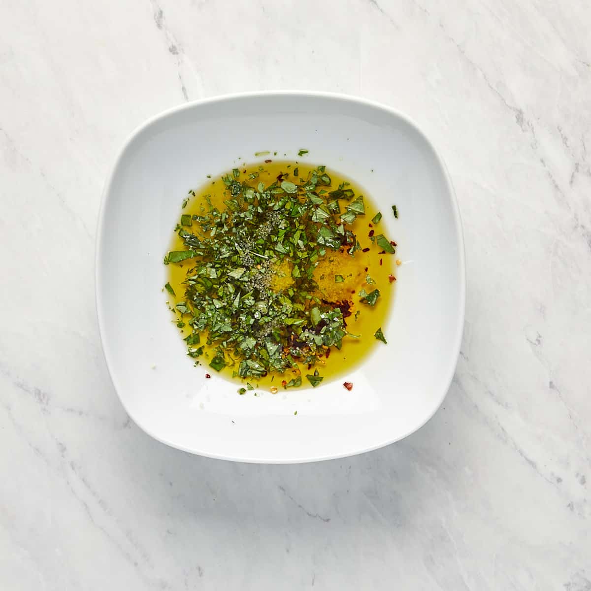 olive oil, basil, and spices in a bowl