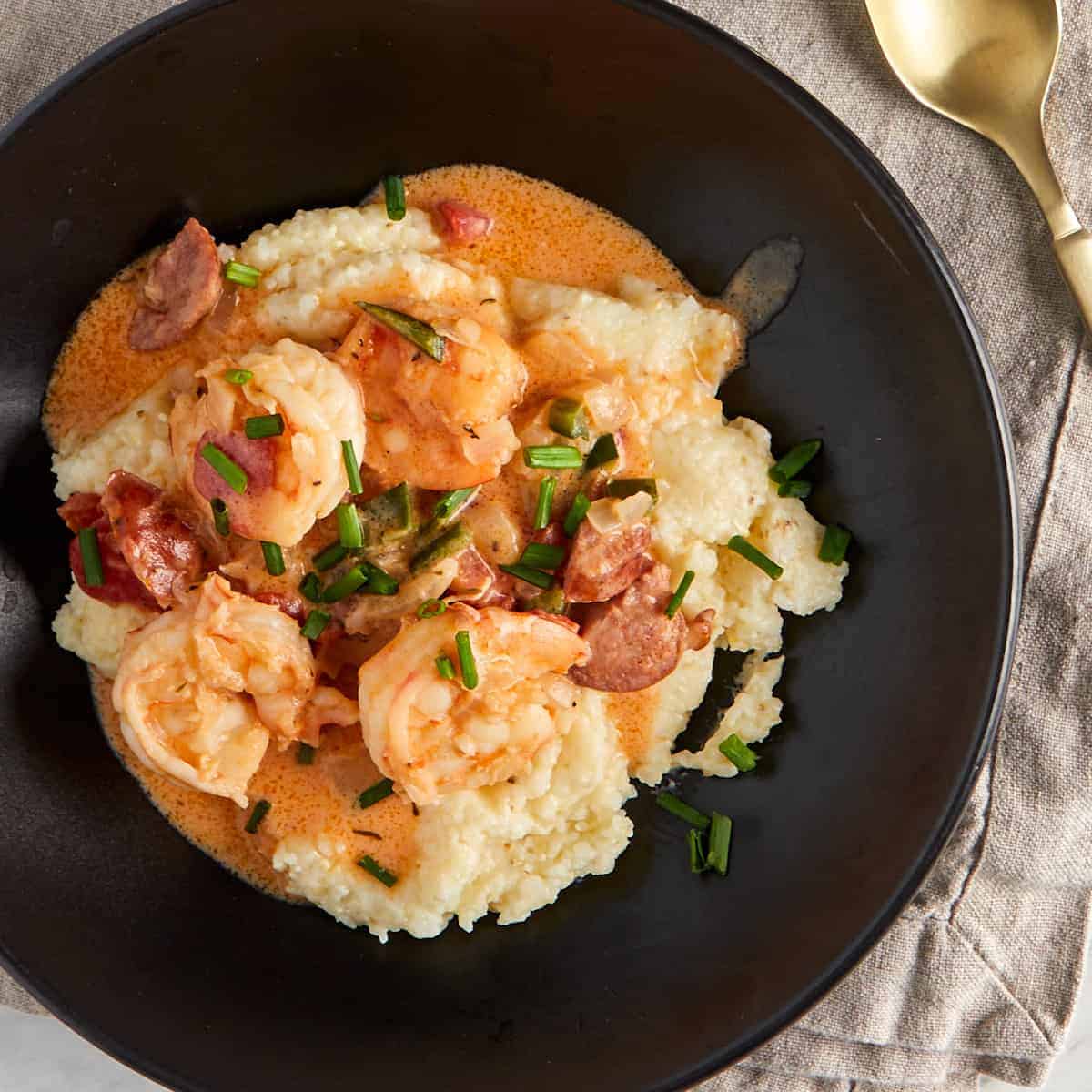 shrimp and grits in a black bowl