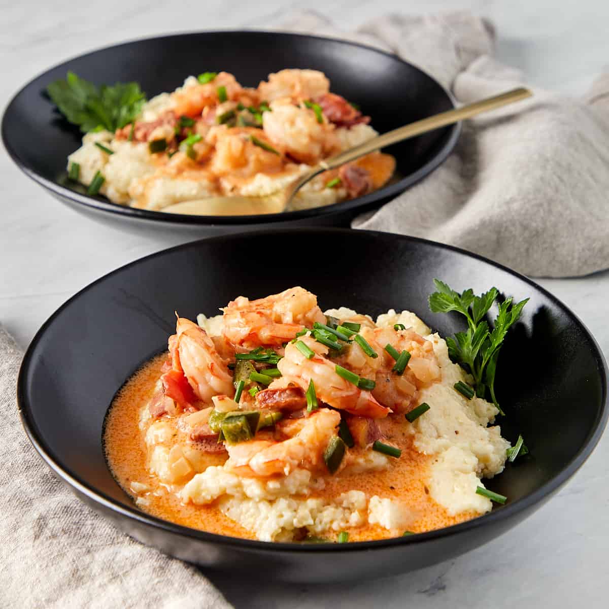 shrimp and grits in a black bowl