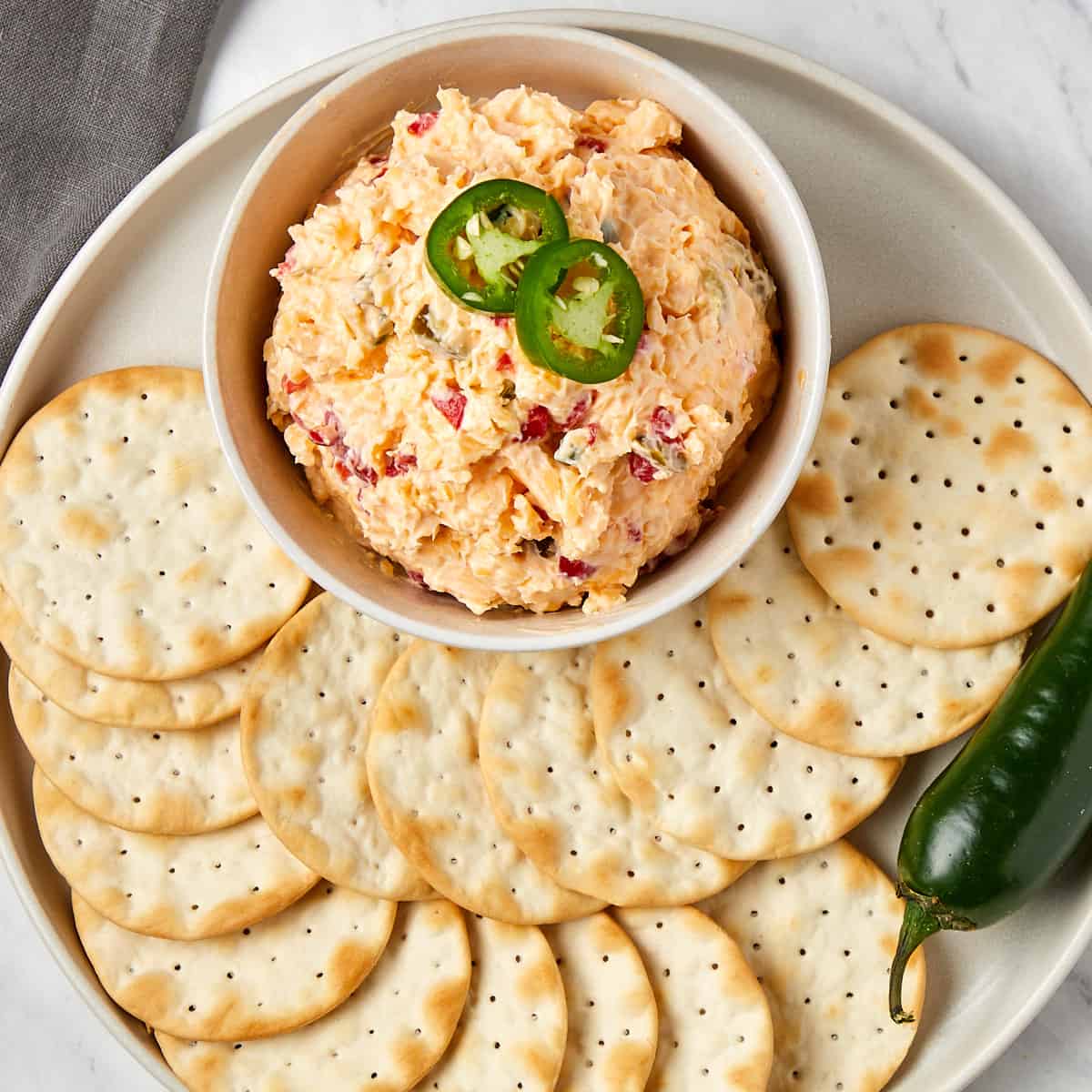 pimento cheese in a bowl with crackers surrounding the bowl