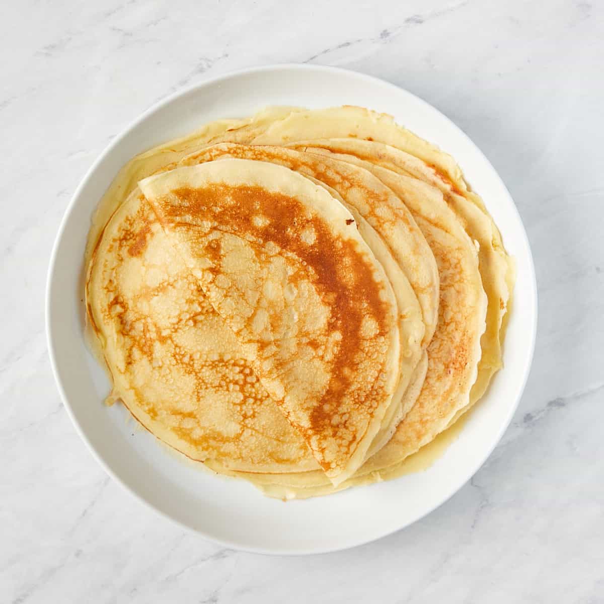 cooked crepes on a white plate