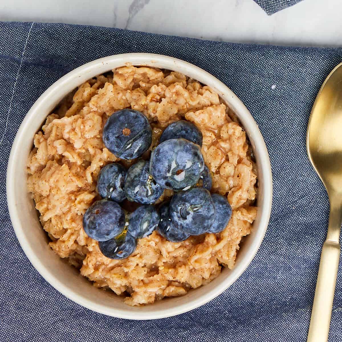 bowl of oatmeal topped with blueberries and honey