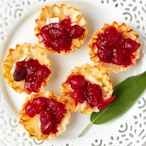 cranberry brie mini tarts on a white plate