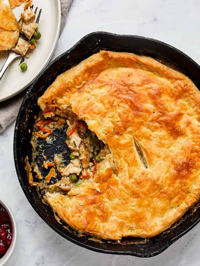 turkey pot pie in cast iron skillet and a serving on a white plate