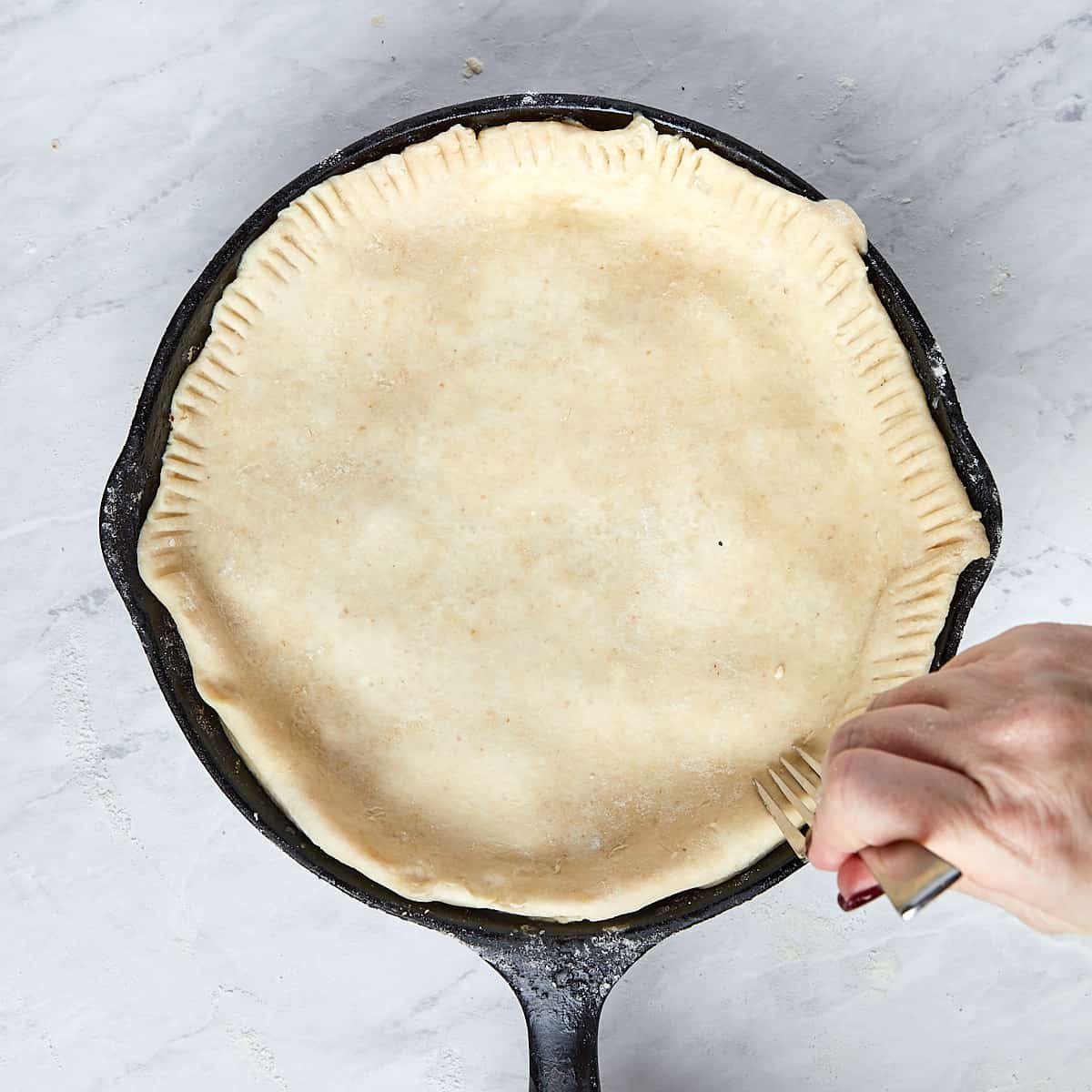 puff pastry edges being crimped with a fork