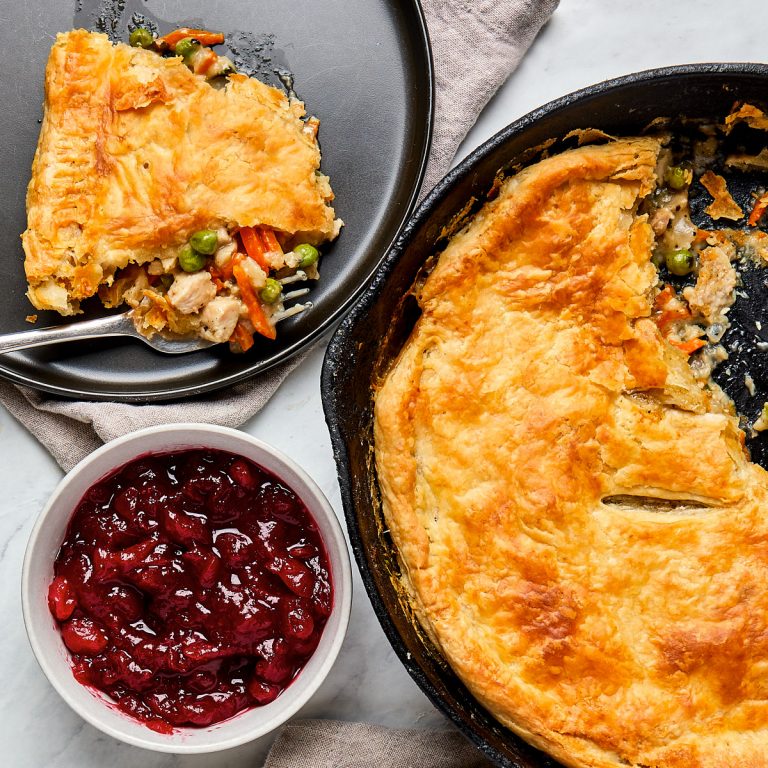 turkey pot pie in cast iron skillet and a serving on a black plate