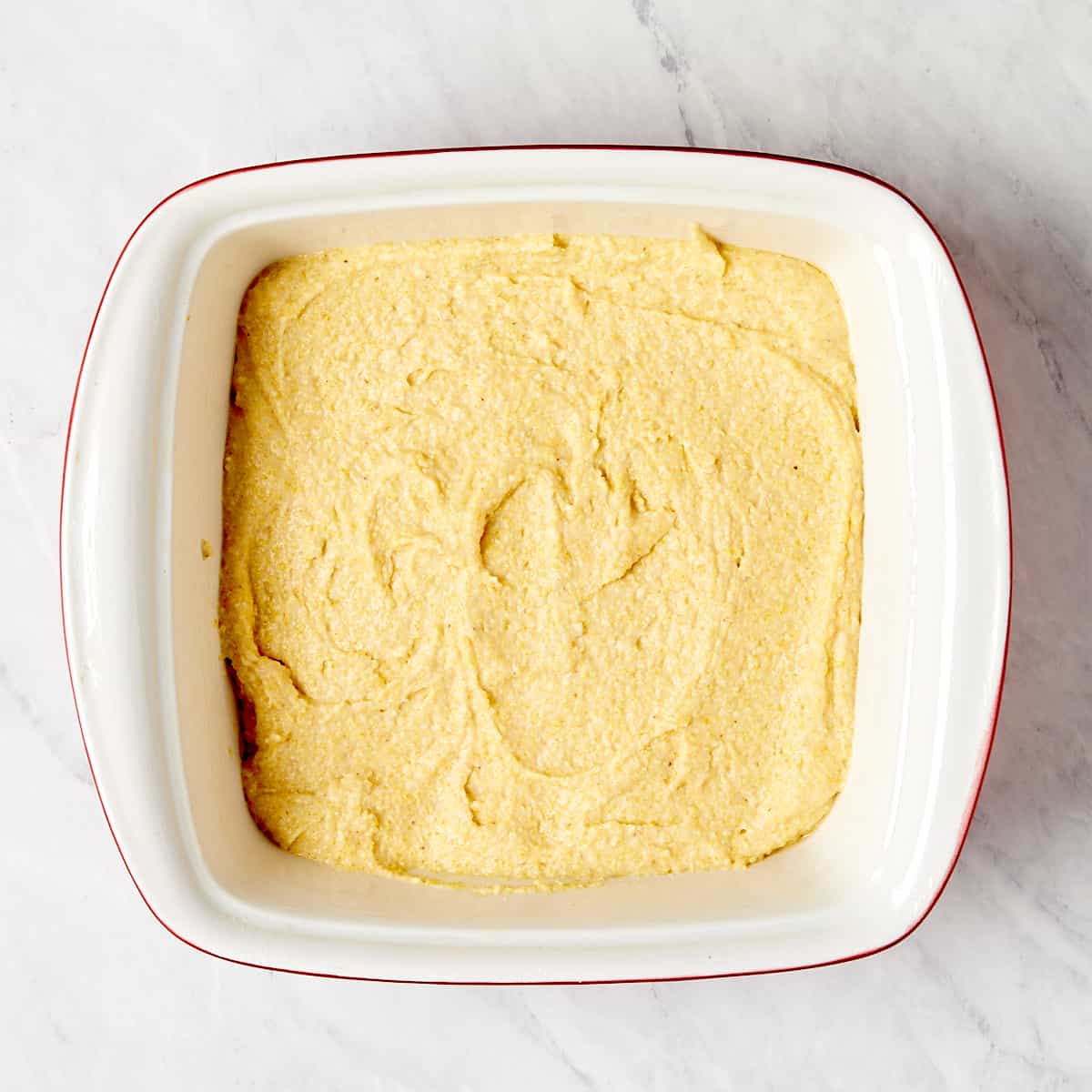 uncooked cornbread in a baking pan