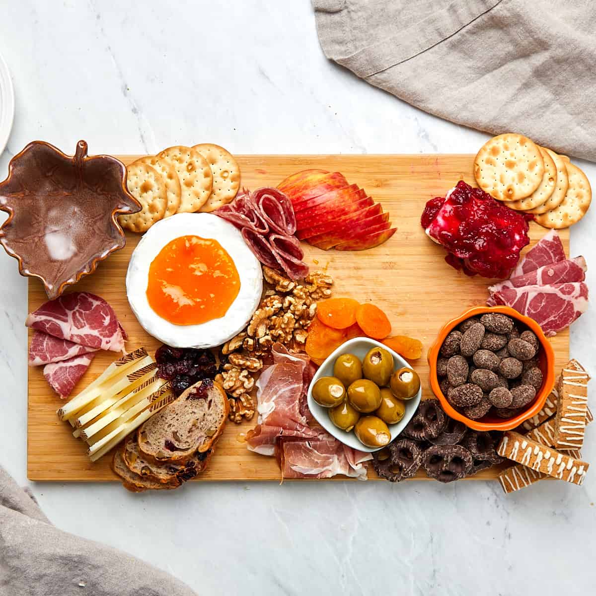 charcuterie board being assembled on wood board