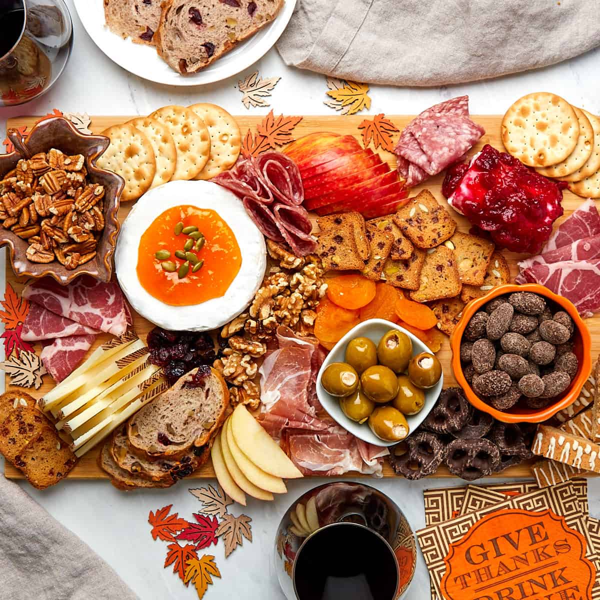charcuterie board assembled on wood board served with glasses of wine