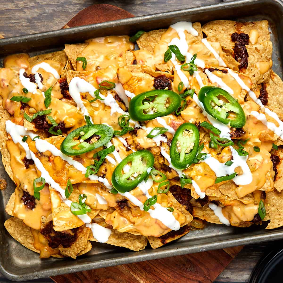 chili cheese nachos on a cookie sheet after coming out of the oven.