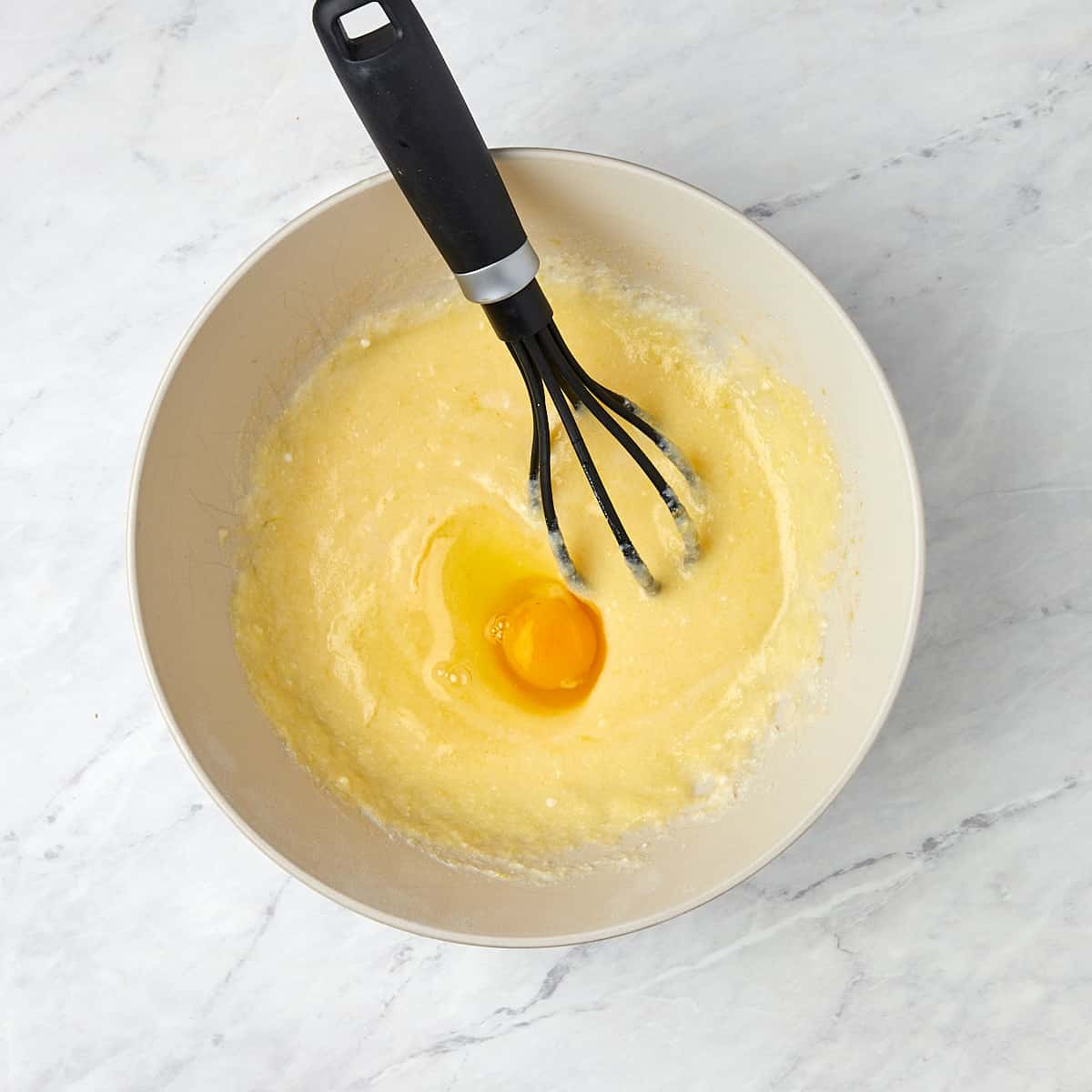 eggs being added one at a time into the cake batter.