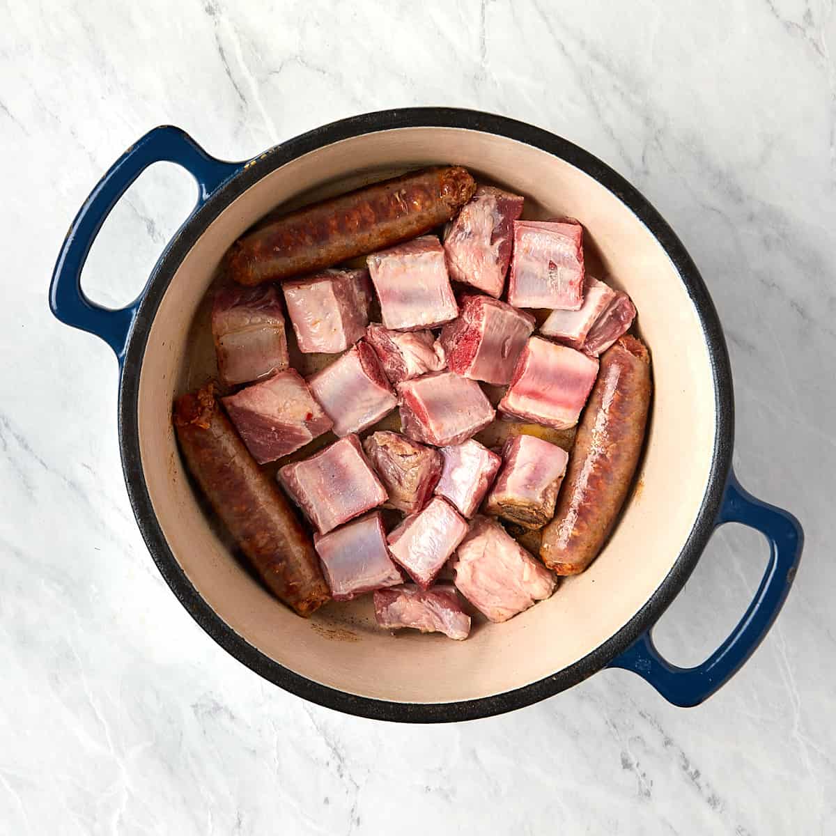 pork tips added to the dutch oven with the sausage.