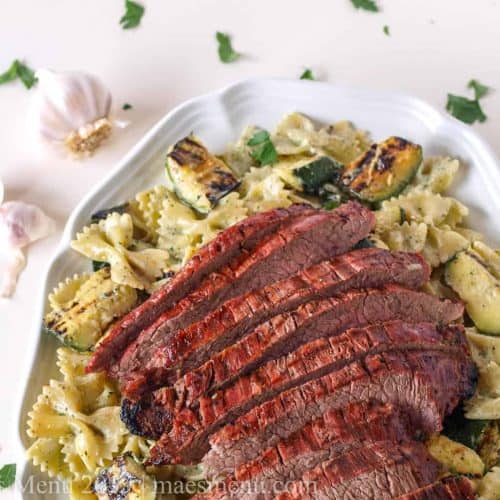 grilled flank steak over pasta chimichurri creme fraiche on a plate