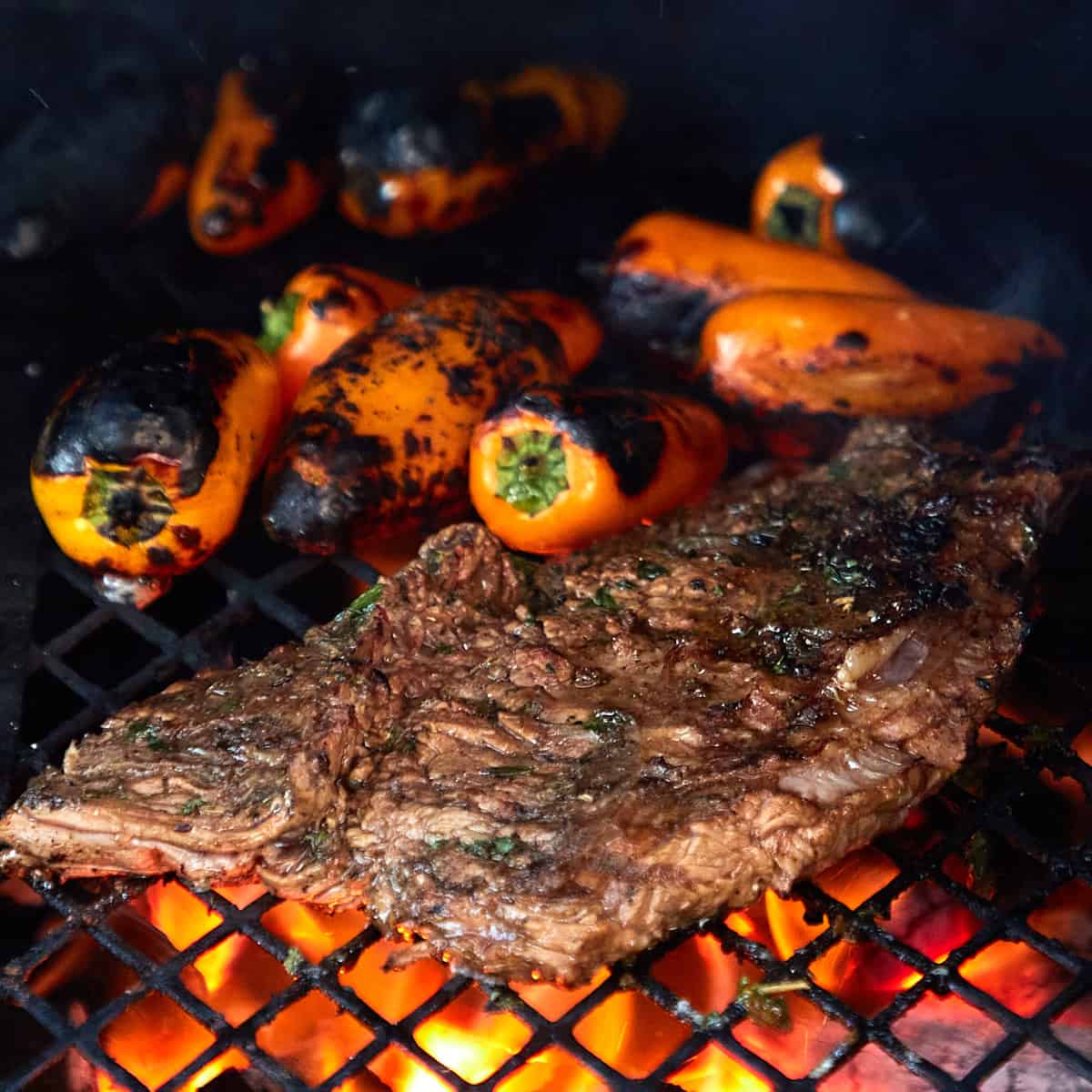 marinated skirt steak being grilled with peppers