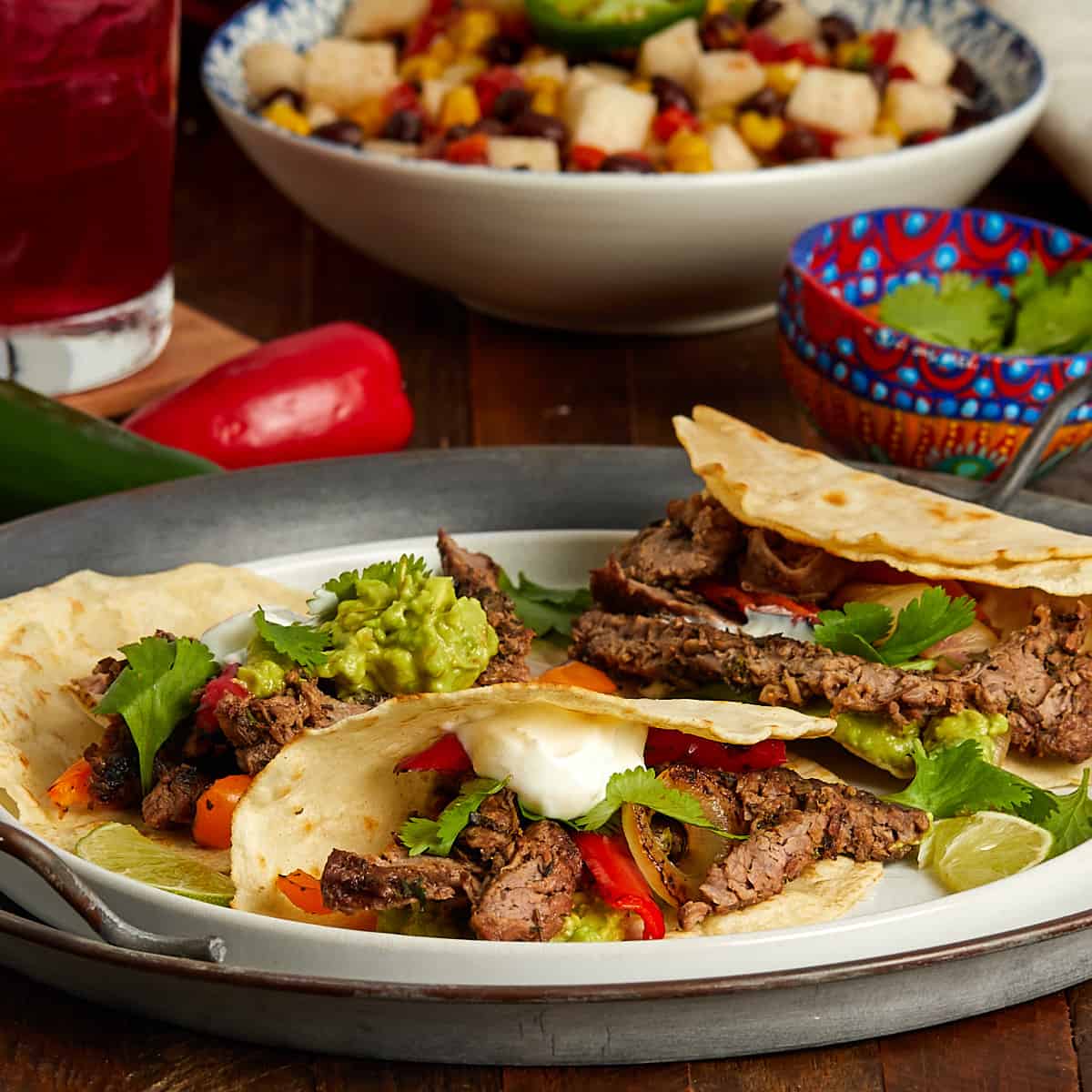 3 beef fajita tacos with sour cream and guacamole on a plate