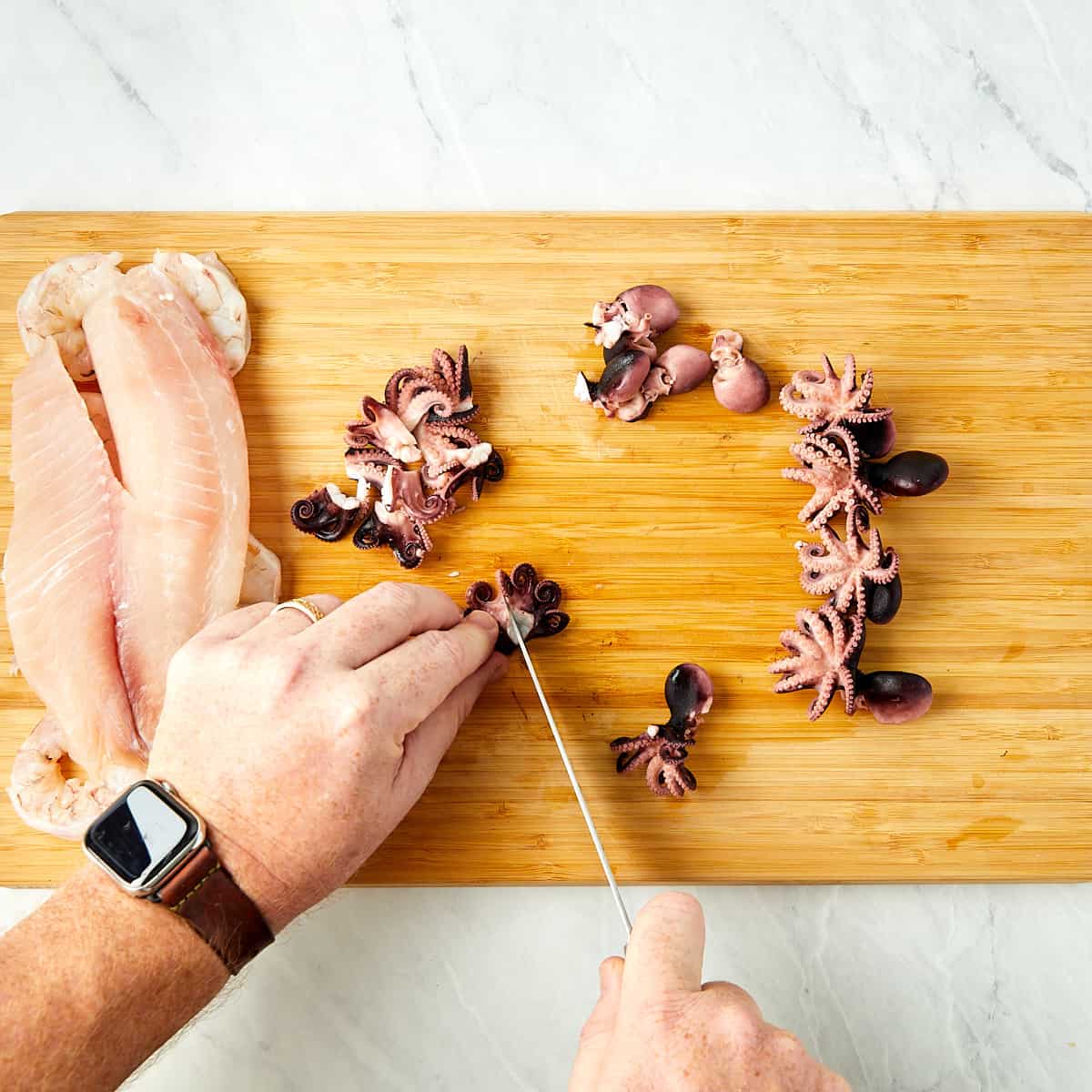 baby octopus being cut up into pieces on a cutting board