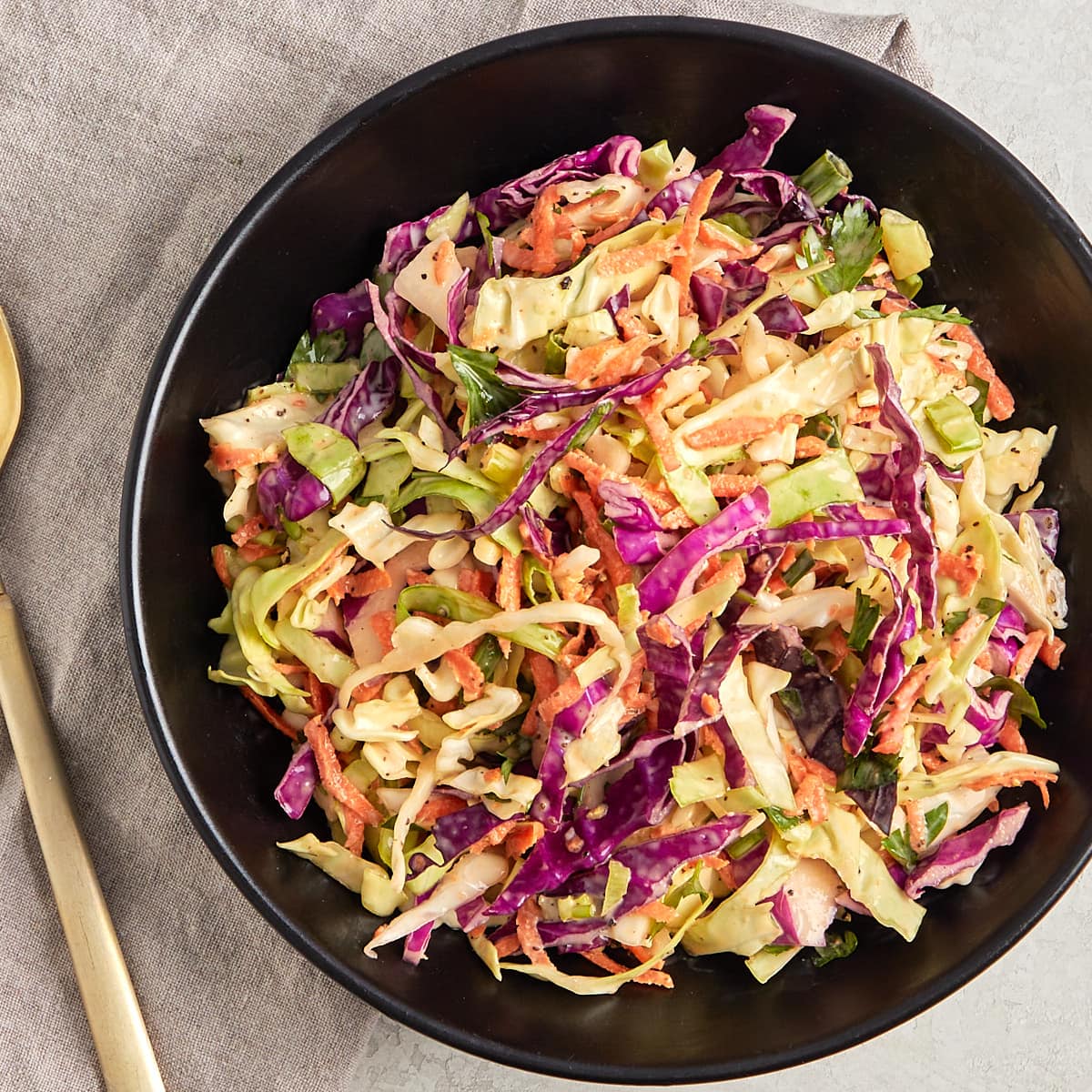 coleslaw in a bowl with a serving spoon.
