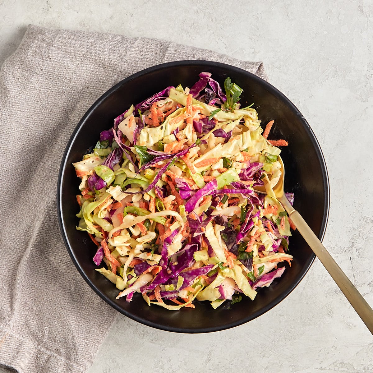 coleslaw in a bowl with a serving spoon.