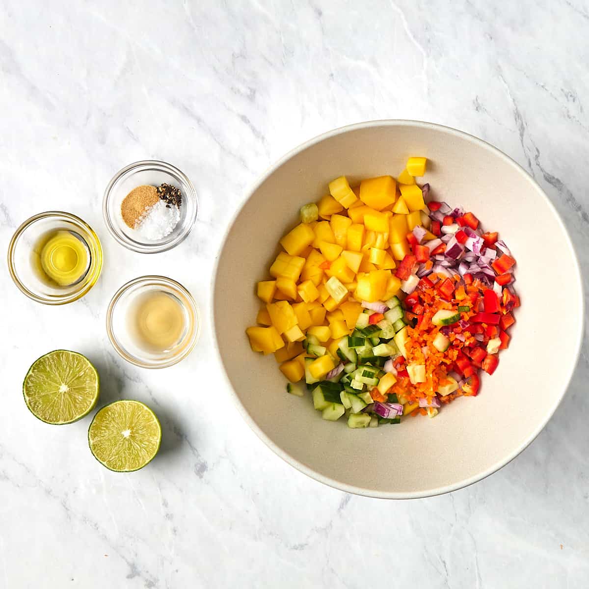 mango salsa in a bowl before adding dressing and being mixed together.