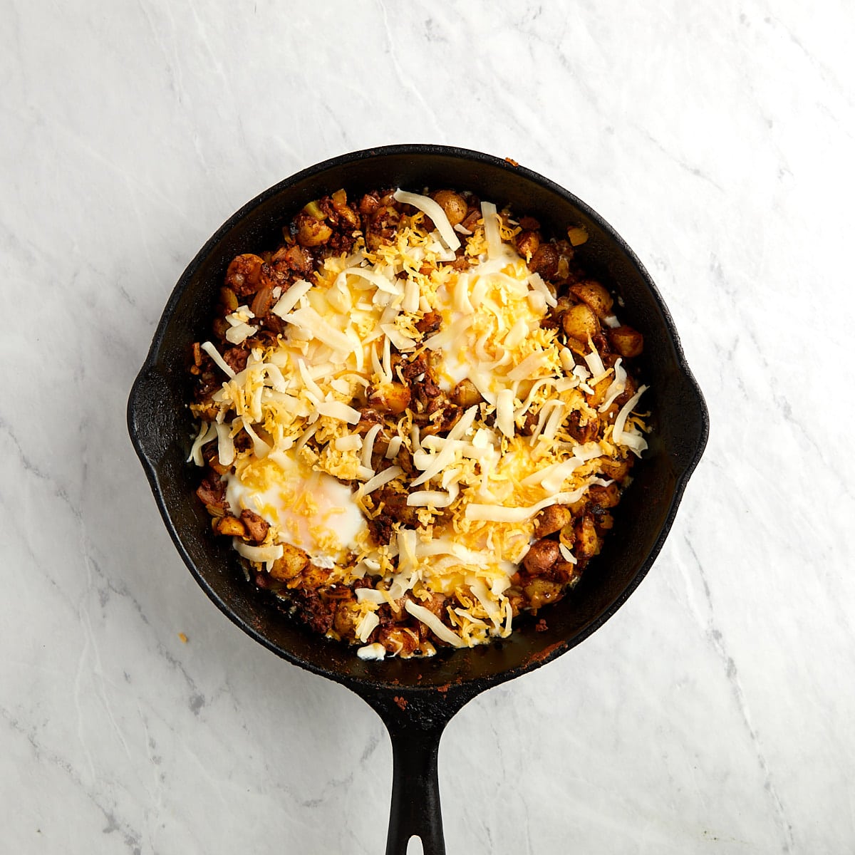 breakfast skillet with shredded cheese added to the top.