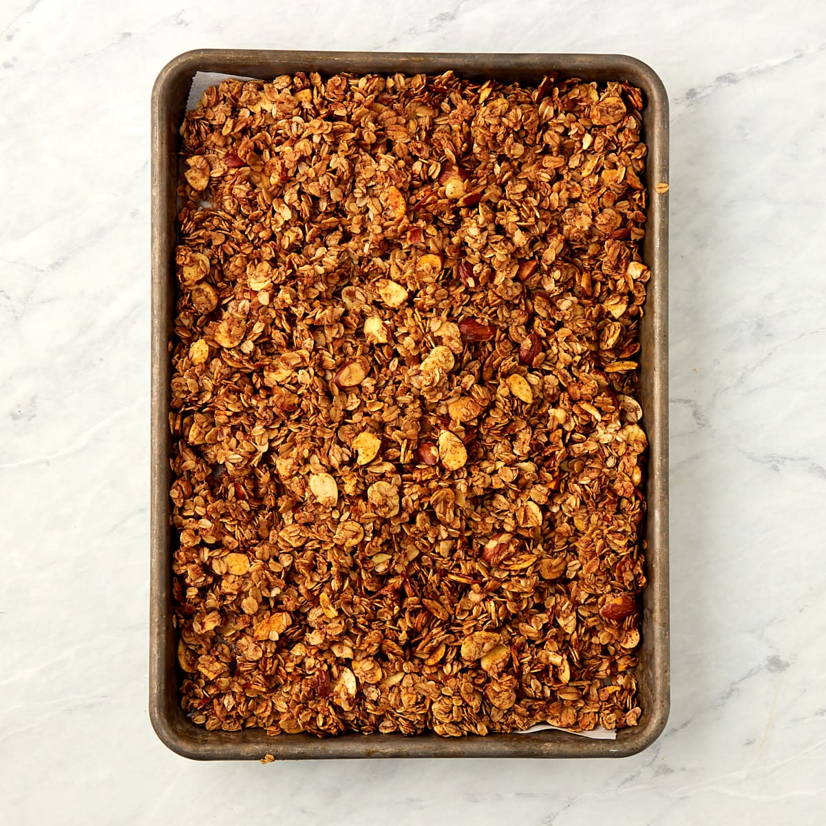cooked granola on a cookie sheet spread into an even layer.