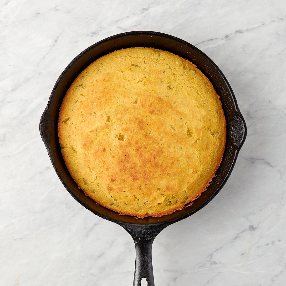 baked green chile cornbread in a cast iron skillet.