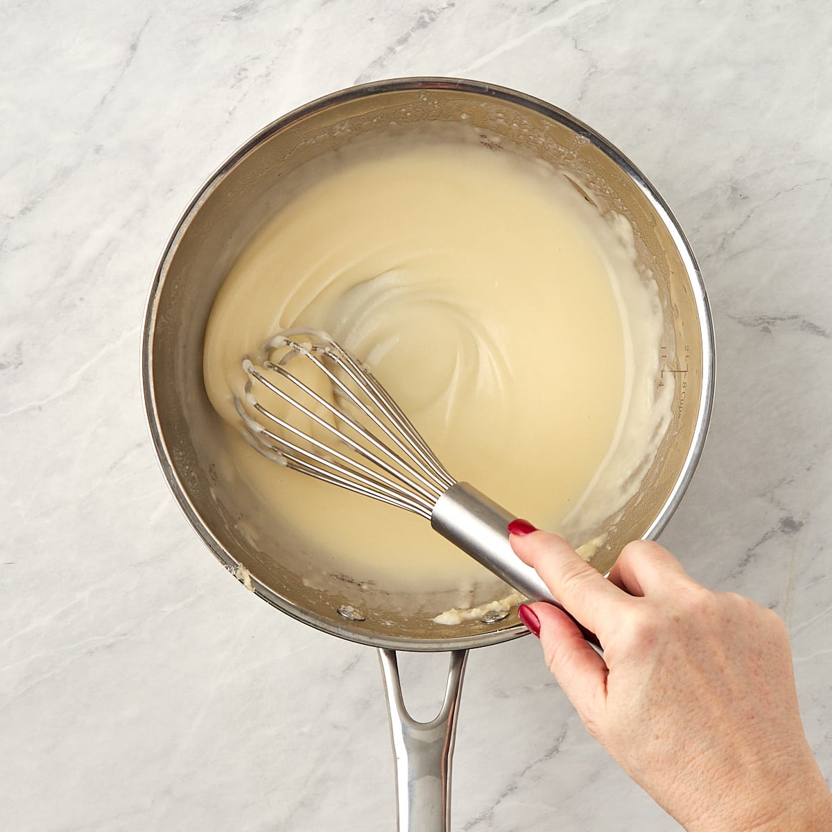 roux being whisked in a skillet.