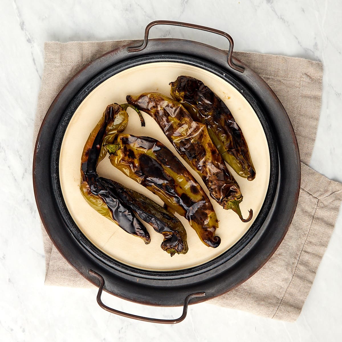 roasted hatch chiles on a plate.