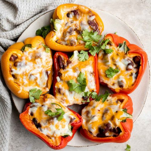 chili and cheese stuffed peppers on a plate.