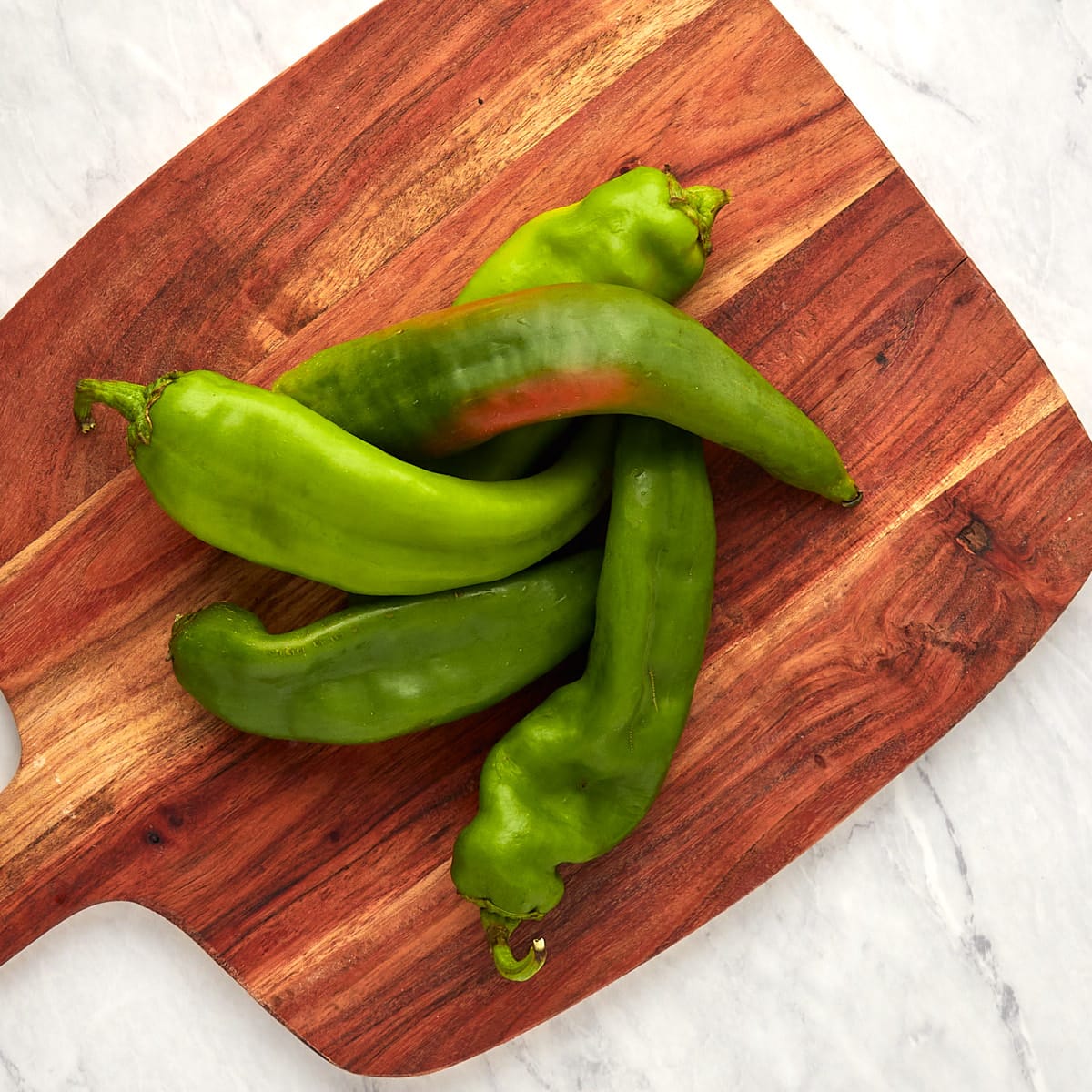 fresh hatch chiles on a wooden board.
