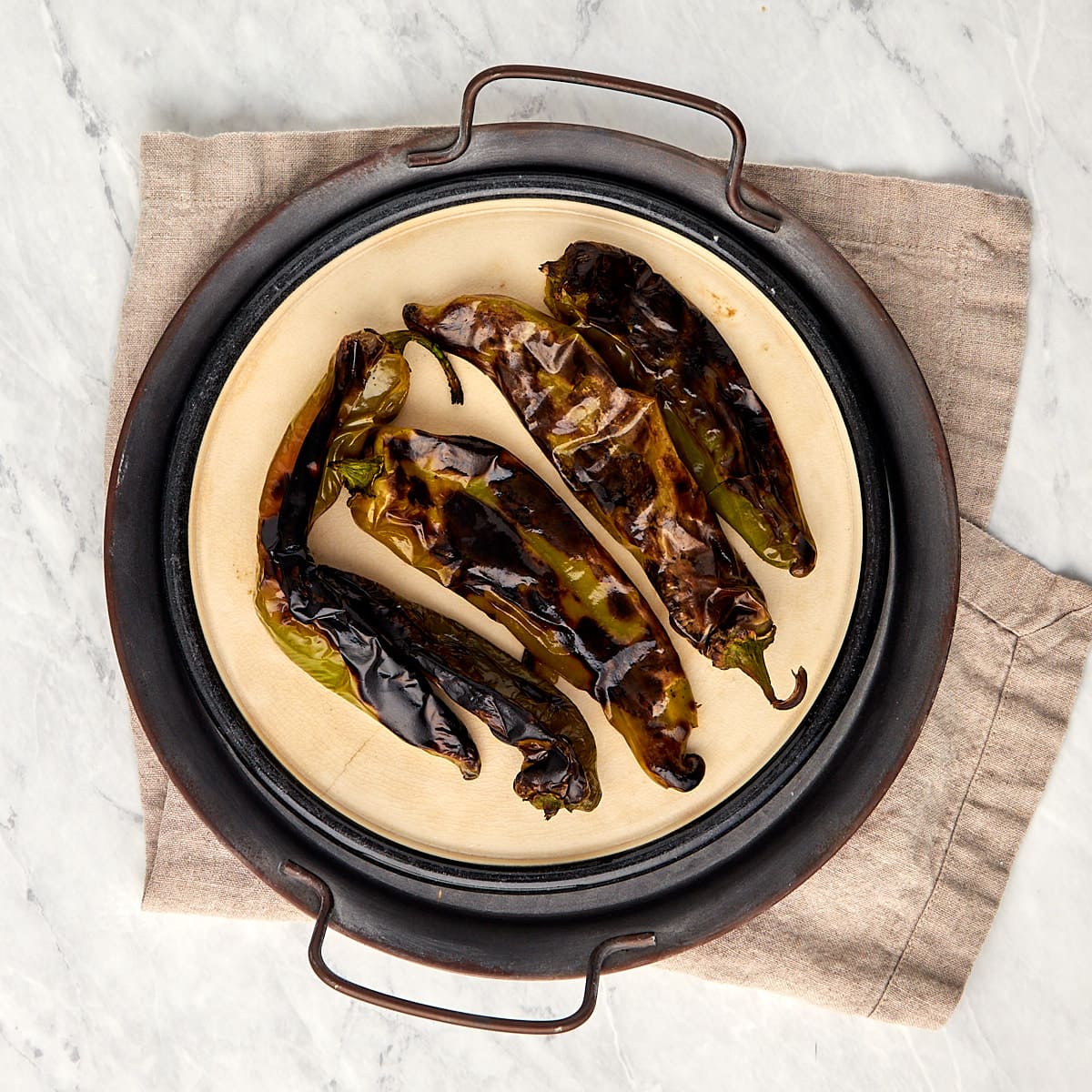roasted hatch chiles on a plate.