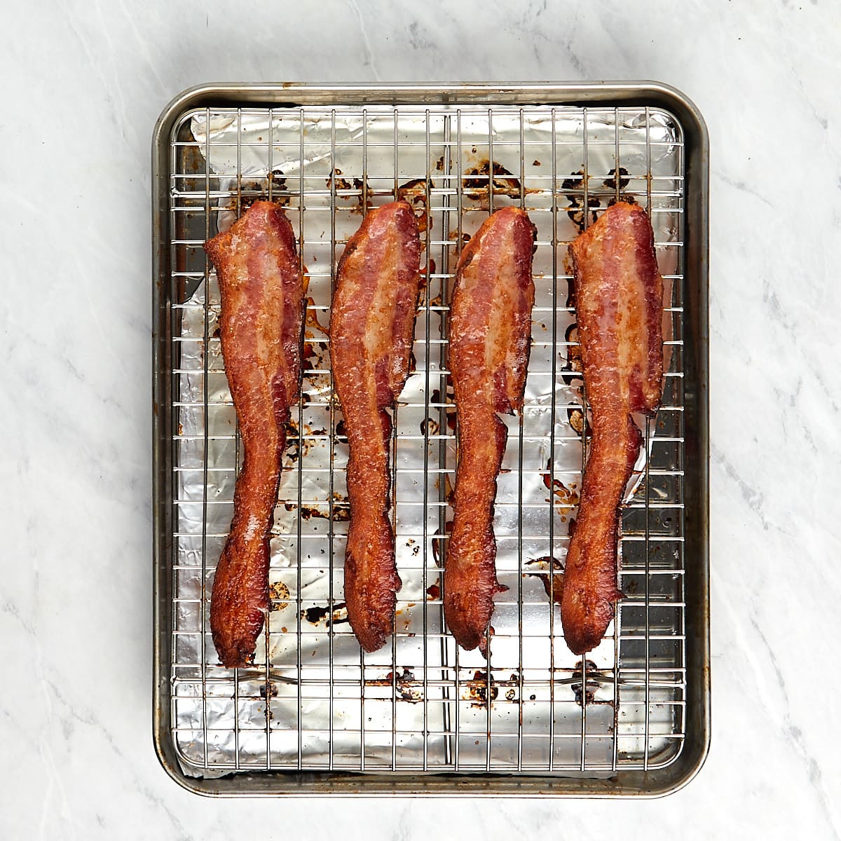 cooked bacon on a wire rack in a baking sheet.