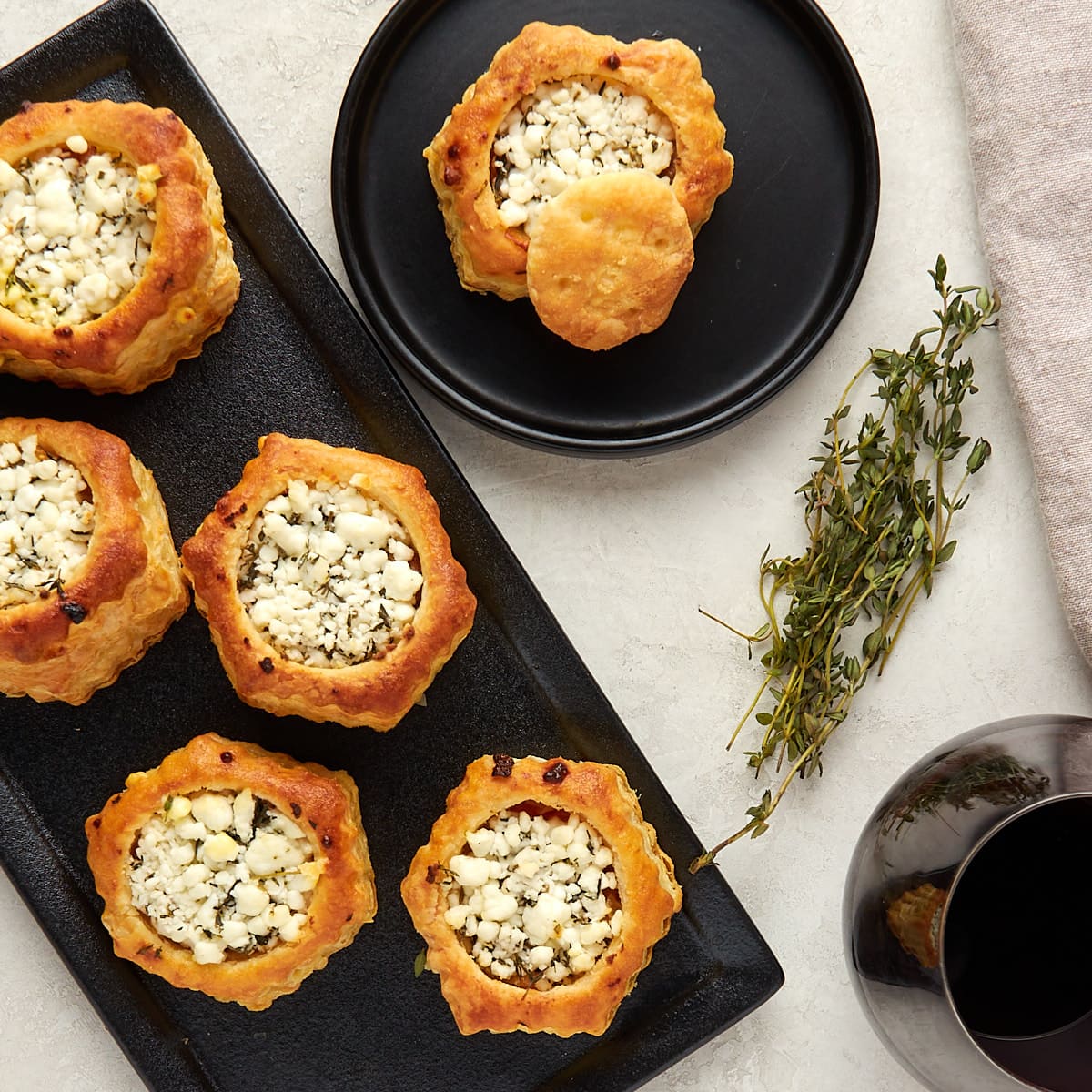 goat cheese caramelized tarts on a black plate.
