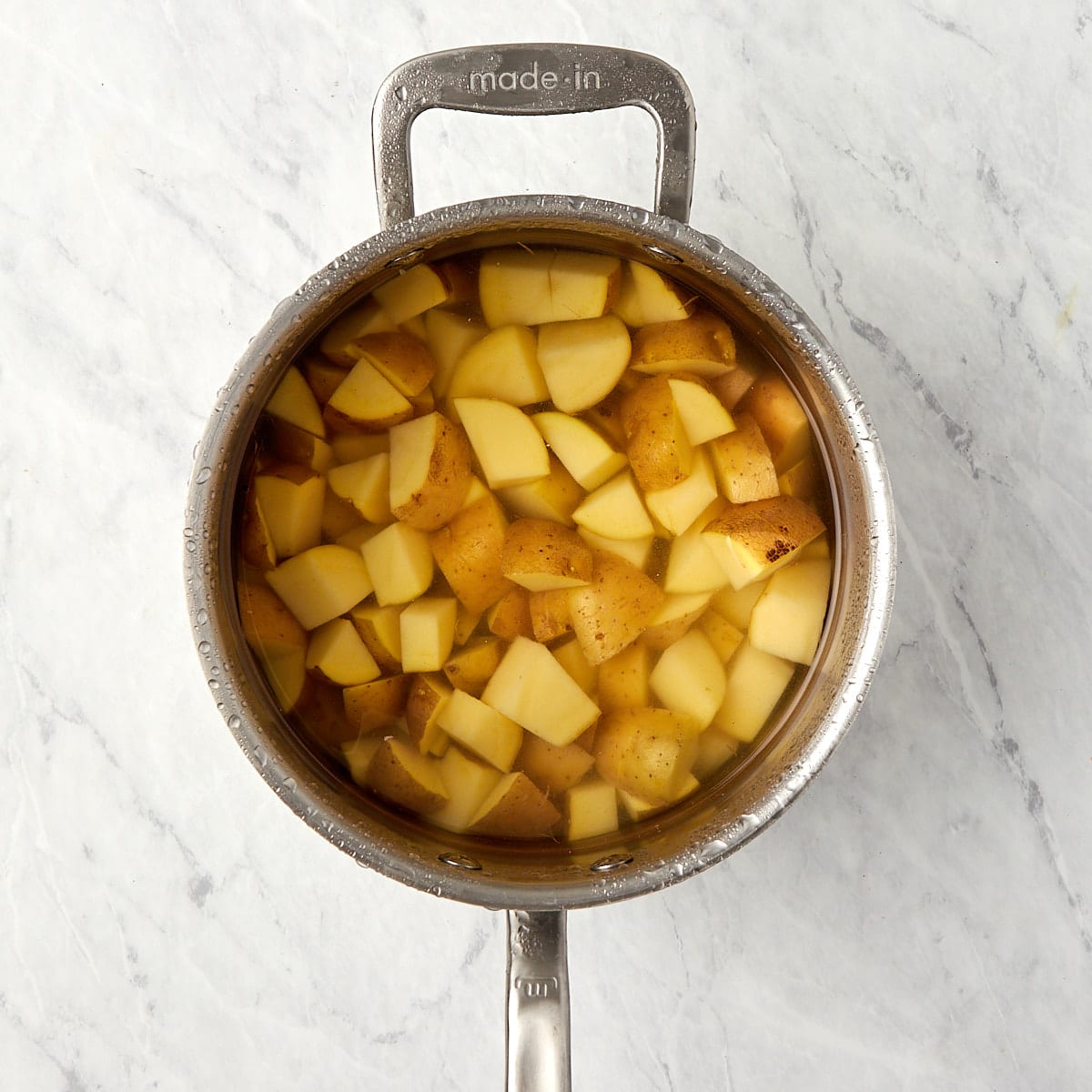 cut up Yukon gold potatoes in a saucepan with water.