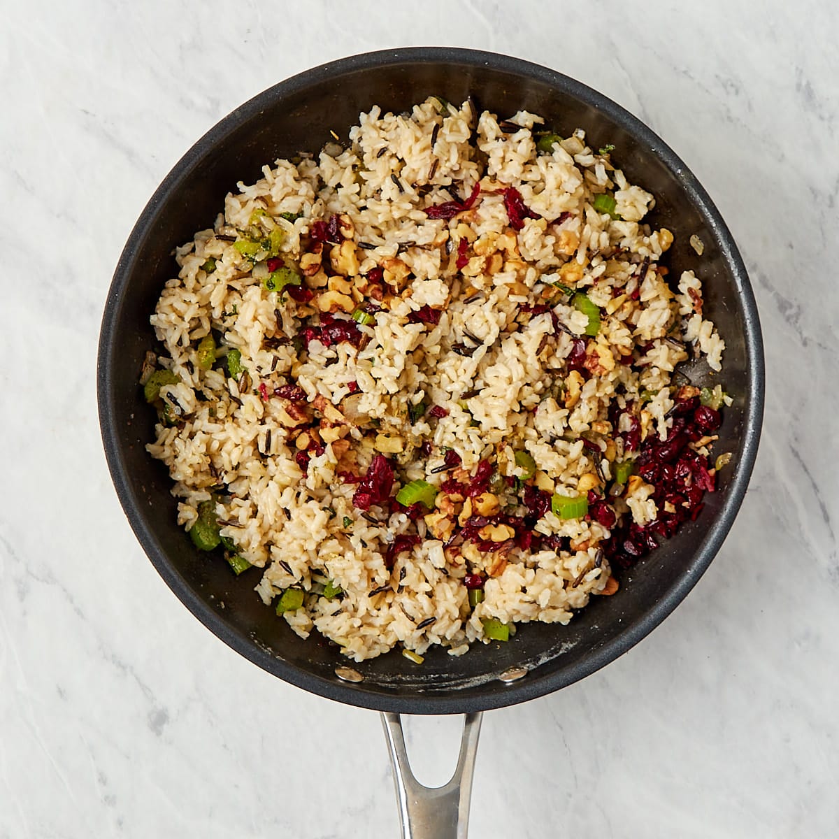 cooked rice, walnuts, and cranberries added to skillet with onions, celery, and herbs.
