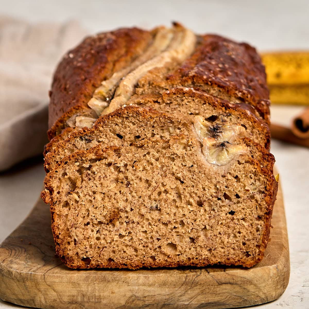 sliced brown butter banana bread on a wooden cutting board.