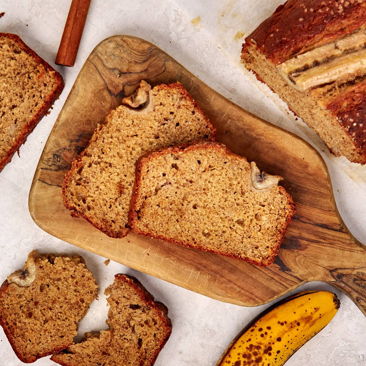 2 slices of banana bread on a wooden cutting board.