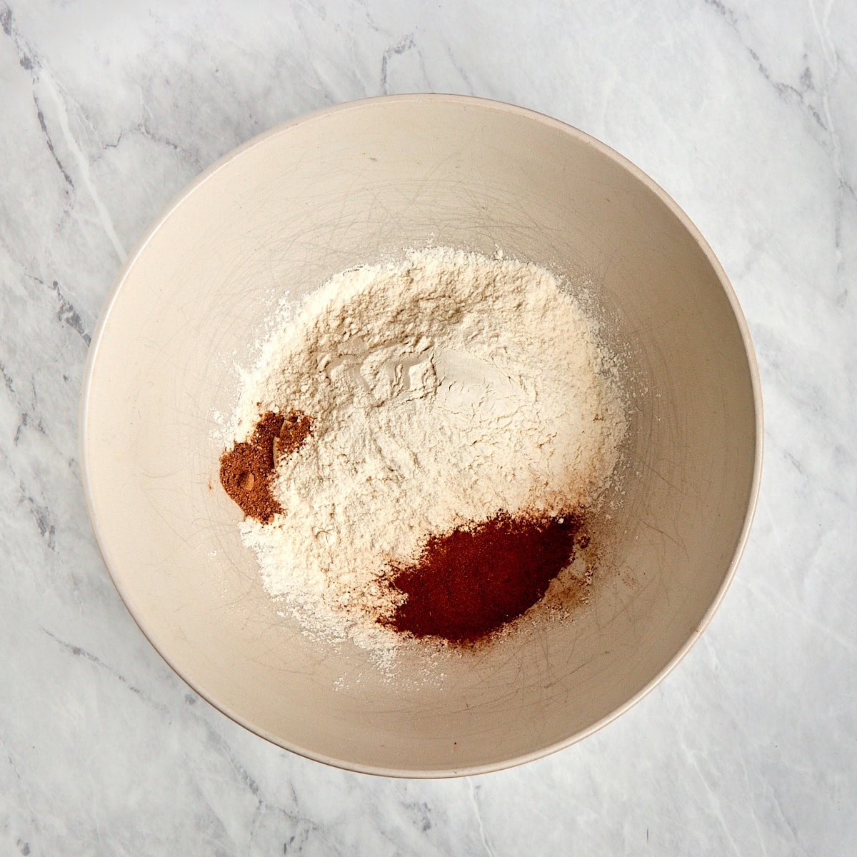 flour, baking soda, baking powder, salt, cinnamon, and nutmeg in a bowl.