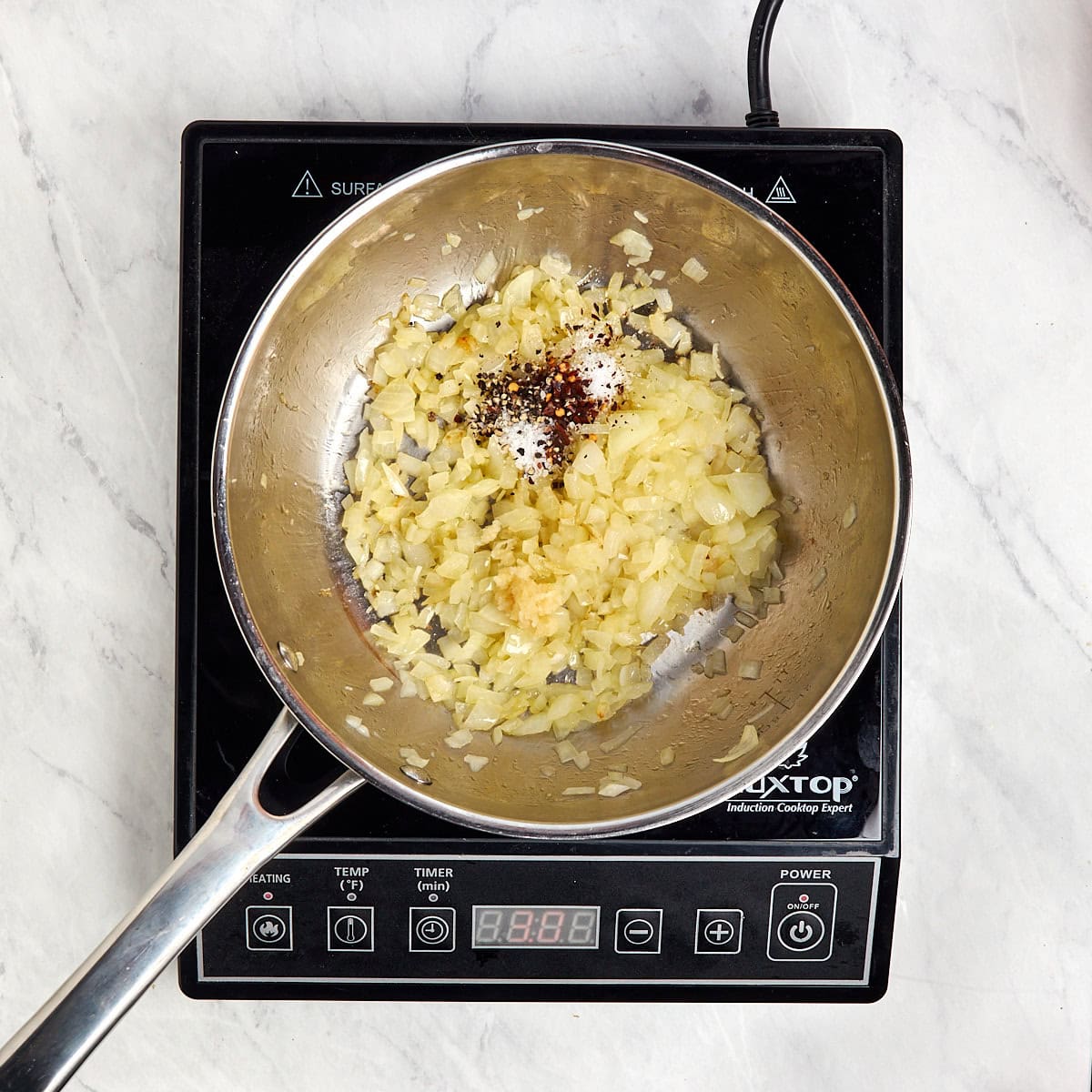 cooked onions in a saucepan with salt, pepper, and chili flakes.