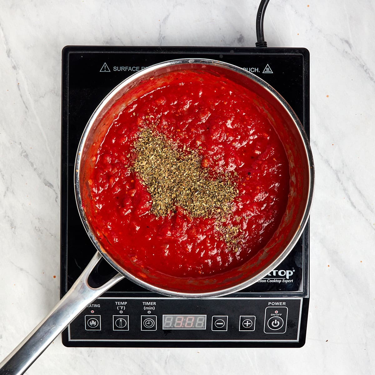 marinara sauce with Italian herbs simmering in a saucepan.