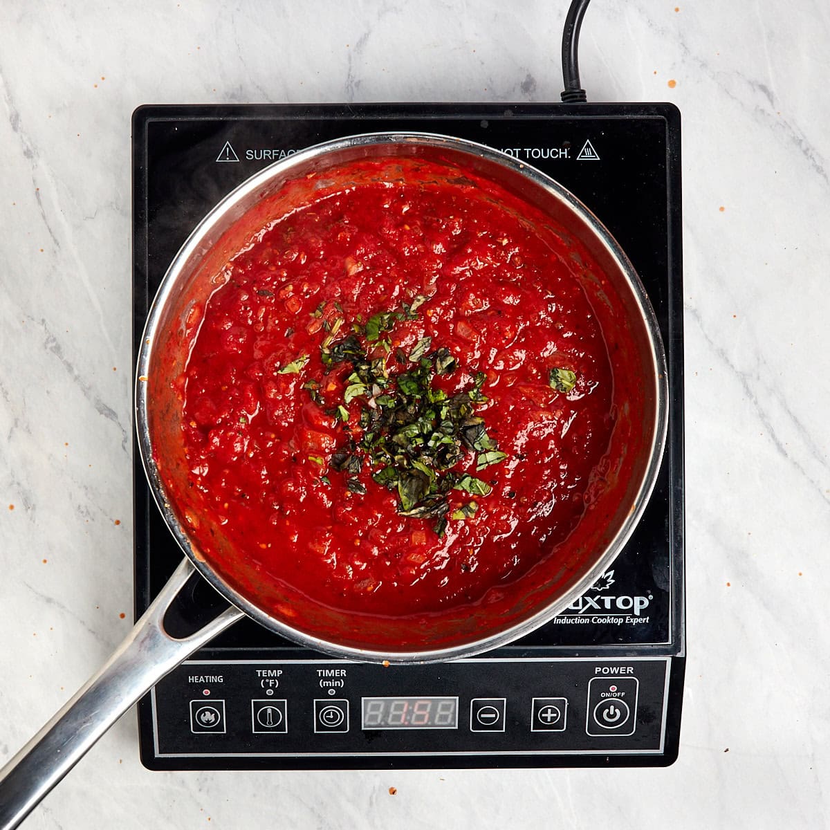 marinara sauce simmering in a saucepan.