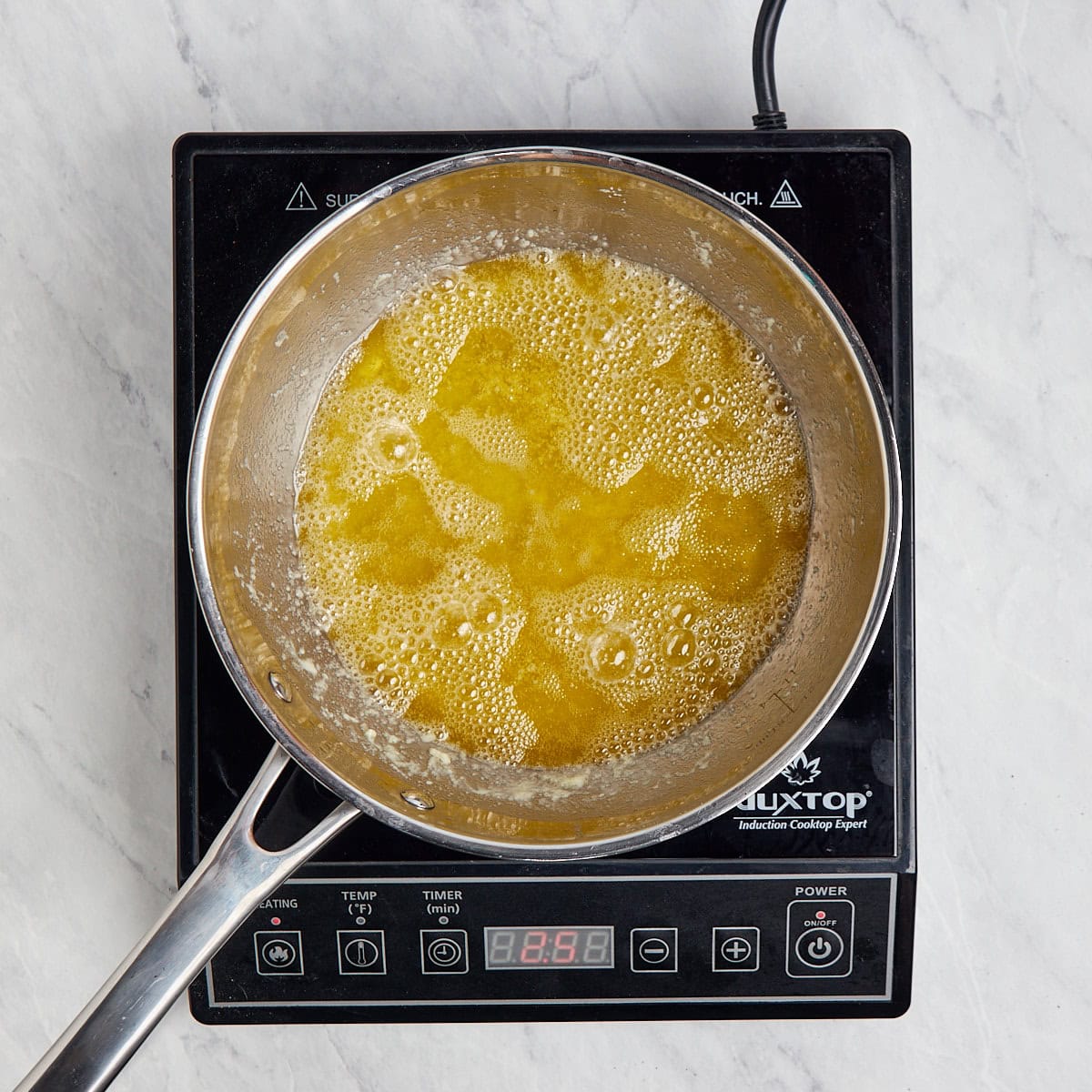 melted butter in a metal saucepan simmering.